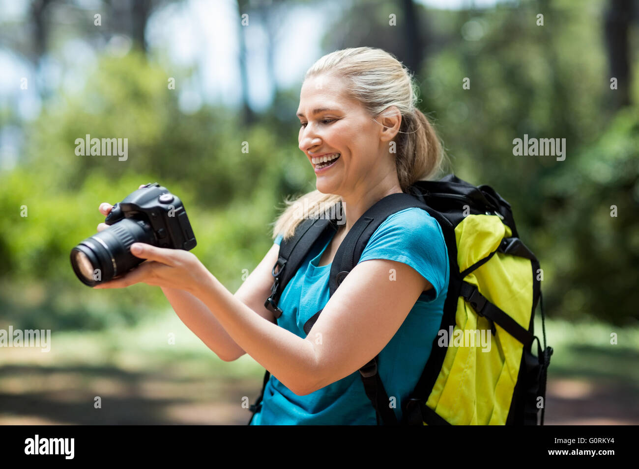 Lächelnde Frau und ihre Kamera suchen Stockfoto