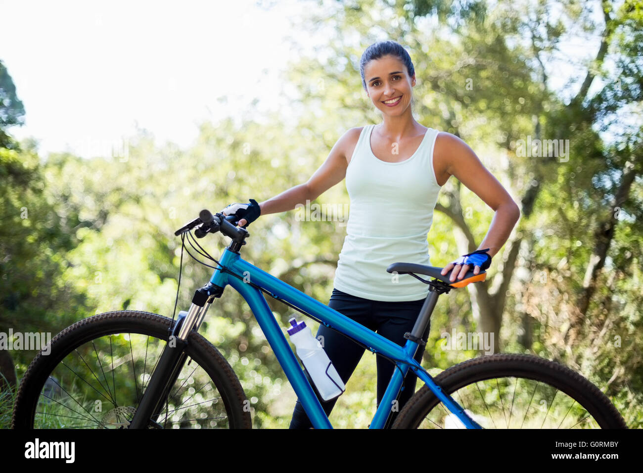 Frau, Lächeln und posieren mit ihrem Fahrrad Stockfoto
