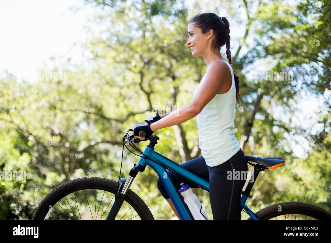 Frau, Lächeln und posieren mit ihrem Fahrrad Stockfoto