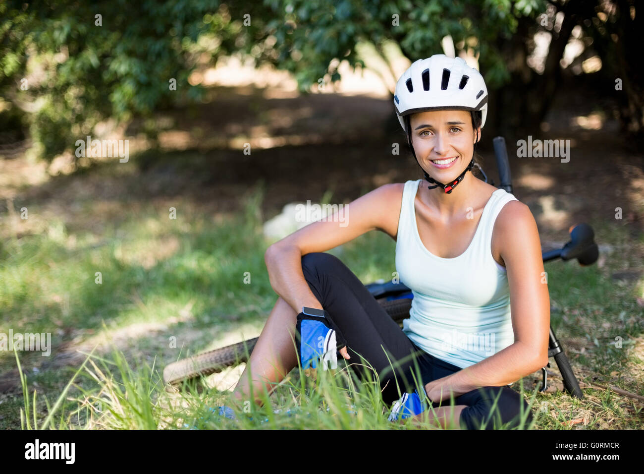 Frau lächelnd und sitzen auf dem Gras Stockfoto