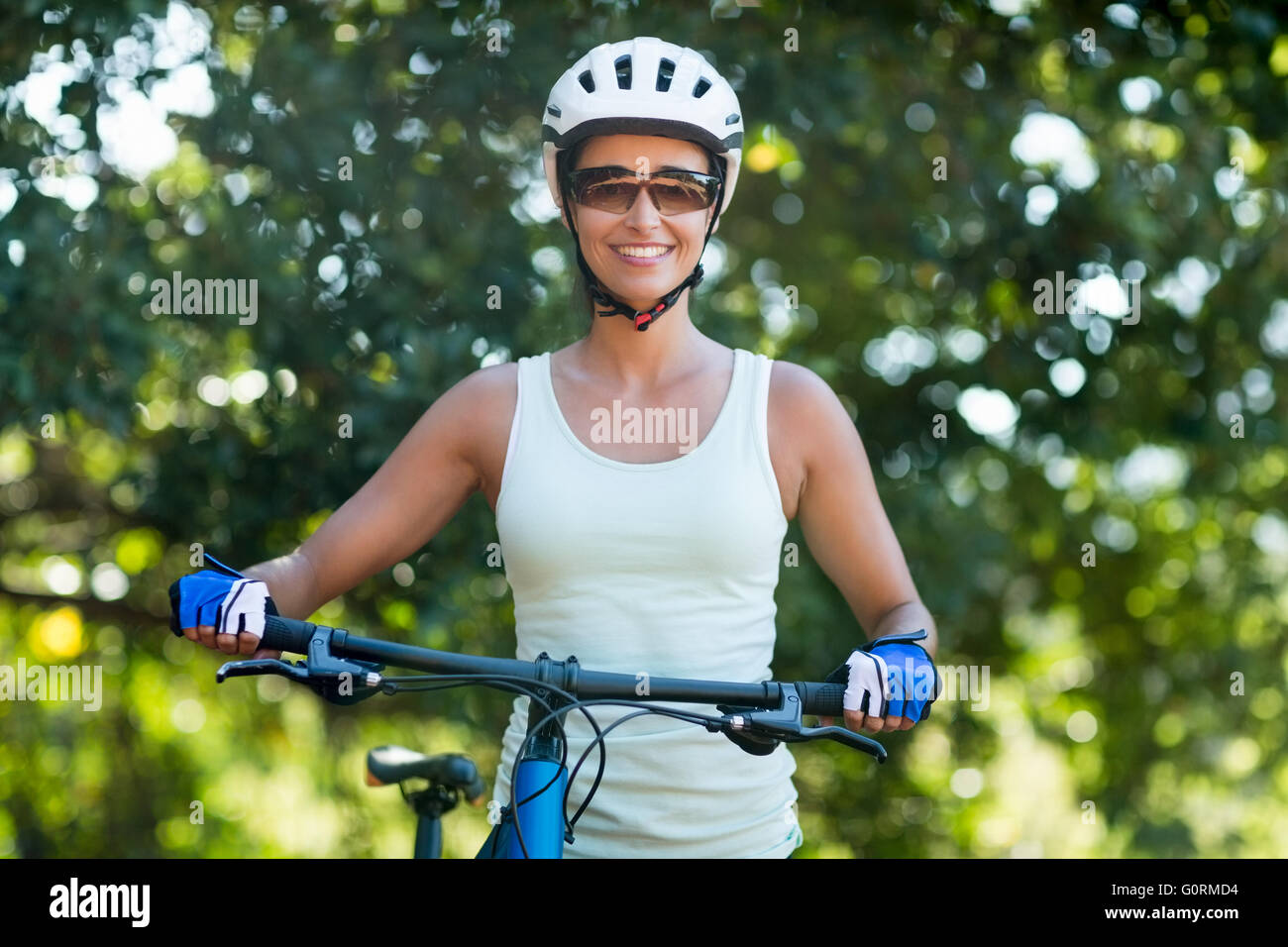 Frau, Lächeln und posieren mit ihrem Fahrrad Stockfoto