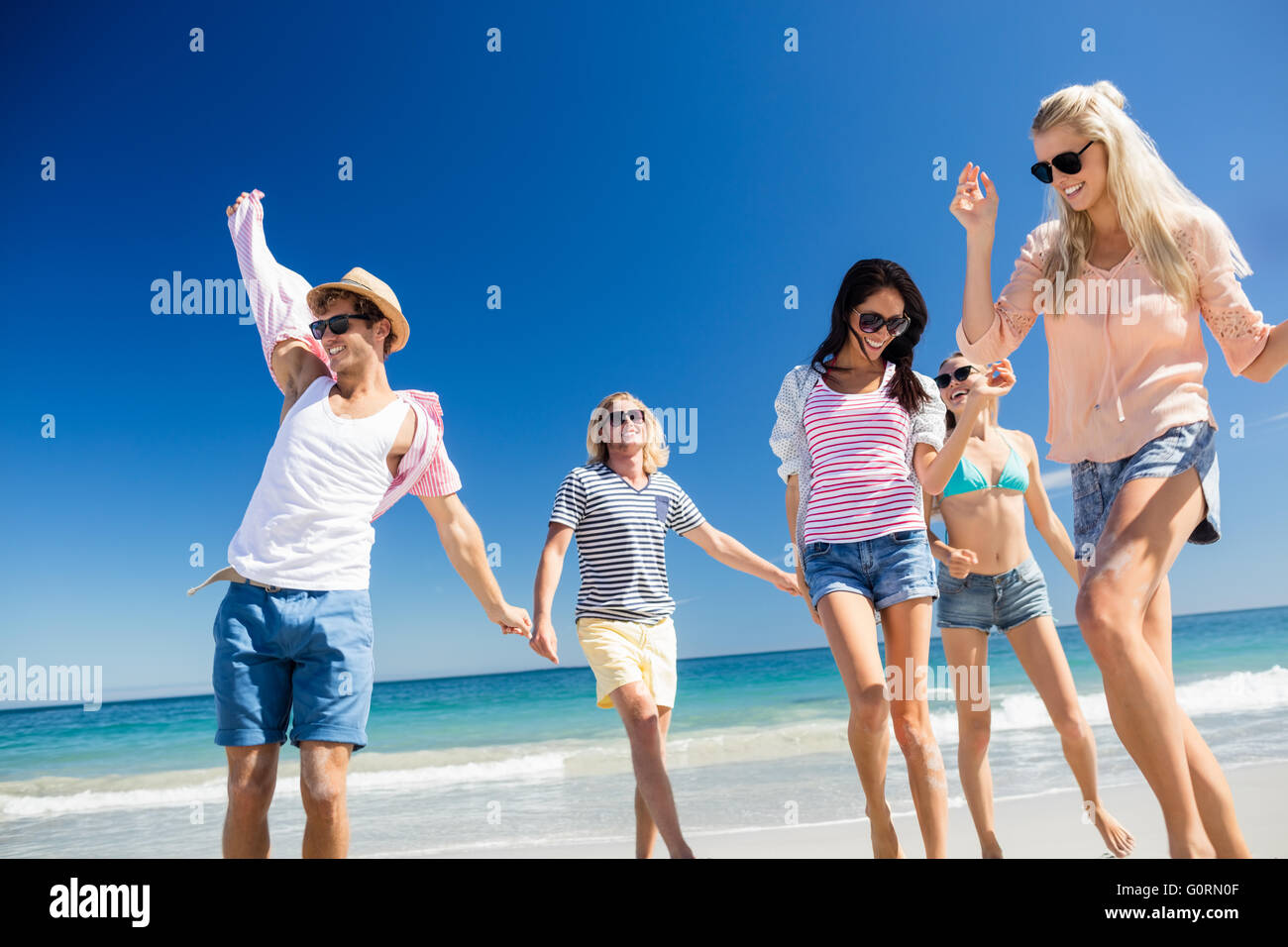 Freunde, tanzen am Strand Stockfoto