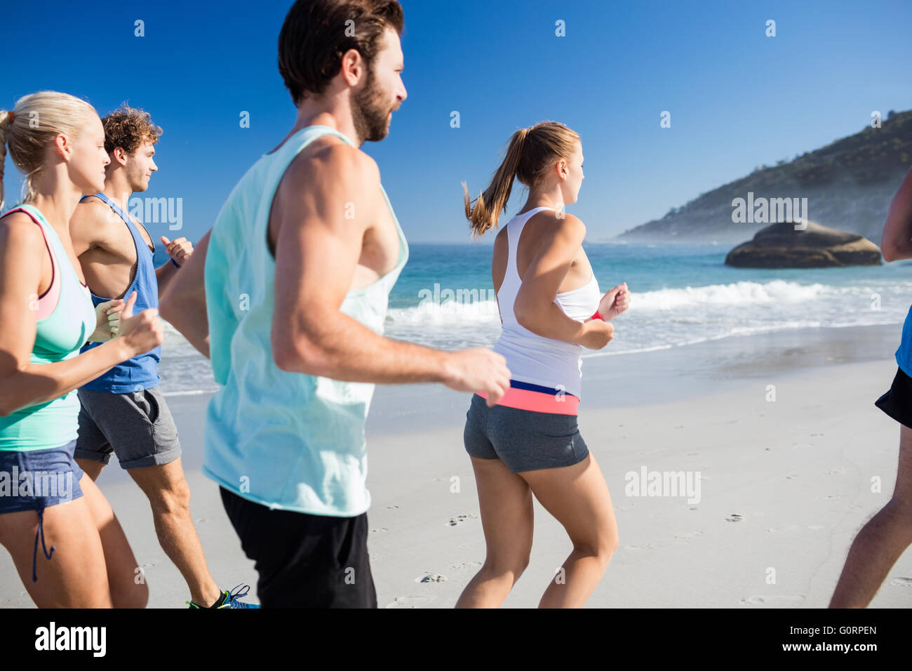 Menschen, die am Strand joggen Stockfoto