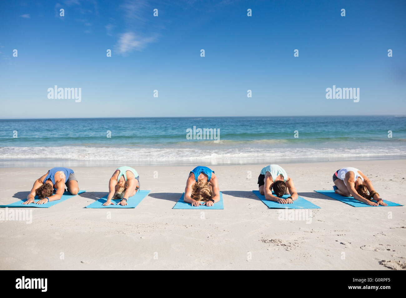 Menschen, die Yoga am Strand Stockfoto