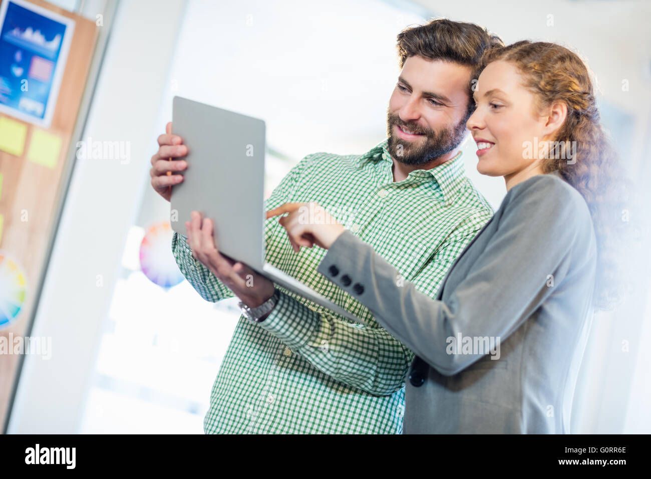 Unternehmer und Unternehmerin diskutieren mit computer Stockfoto