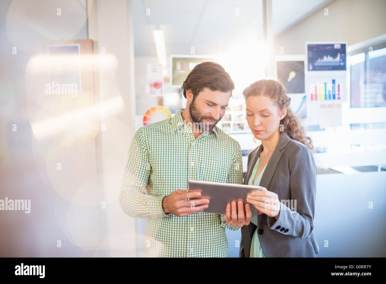Unternehmer und Unternehmerin diskutieren mit tablet Stockfoto