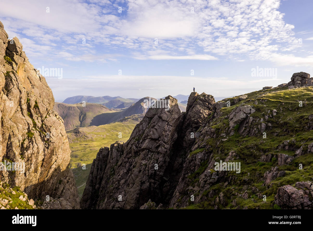 Ein einsamer Wanderer einen Überblick über die Landschaft von der Zinne auf Sca Fell im englischen Lake District. Stockfoto