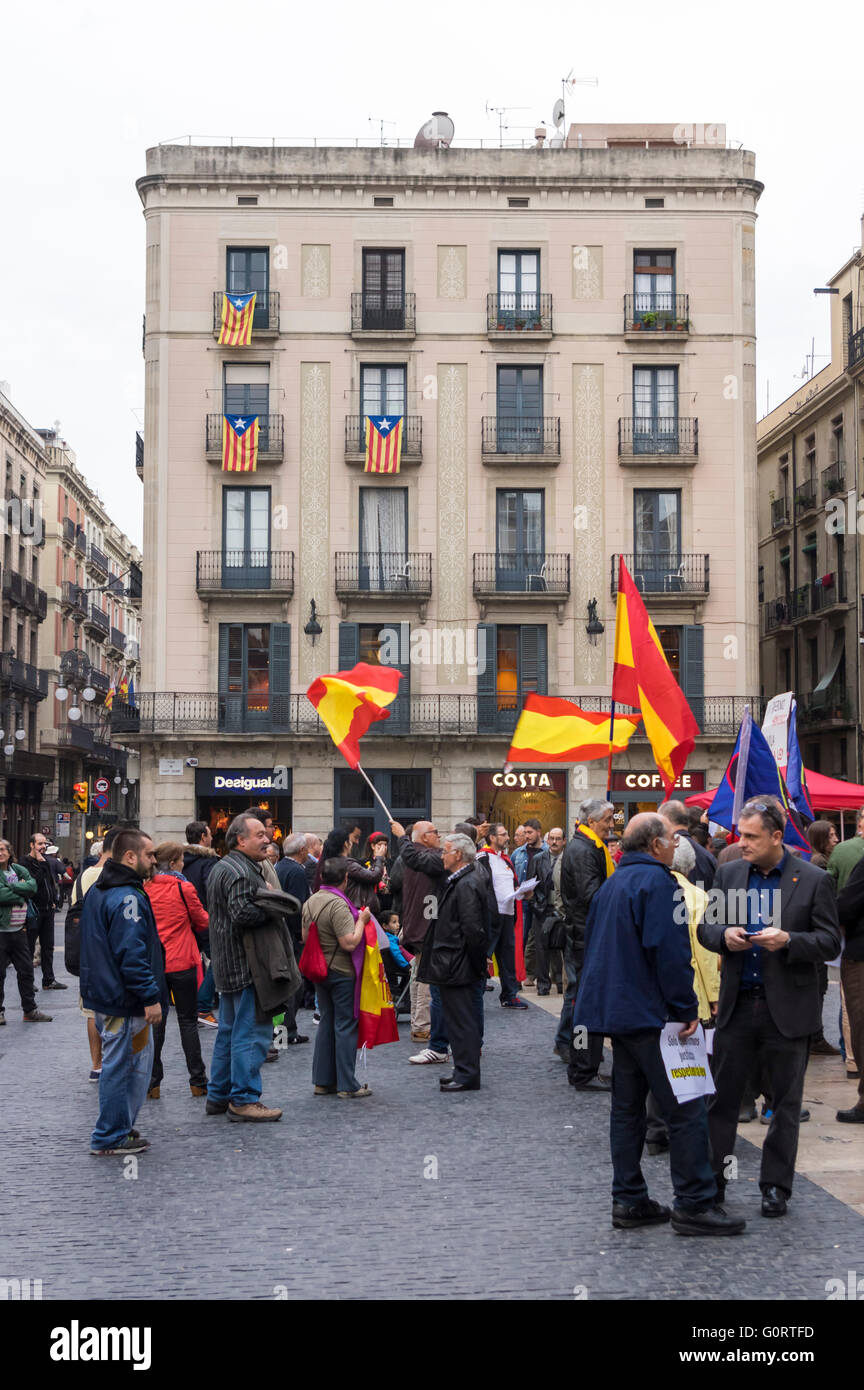 Pro-spanische Demonstranten mit spanischen Flaggen vor einem Haus mit Katalanisch Estelada Fahnen. Barcelona, April 2016. Stockfoto