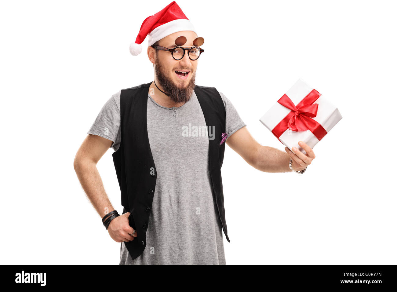 Mann mit Brille Hipster und Weihnachtsmütze hält ein Geschenk isoliert auf weißem Hintergrund Stockfoto