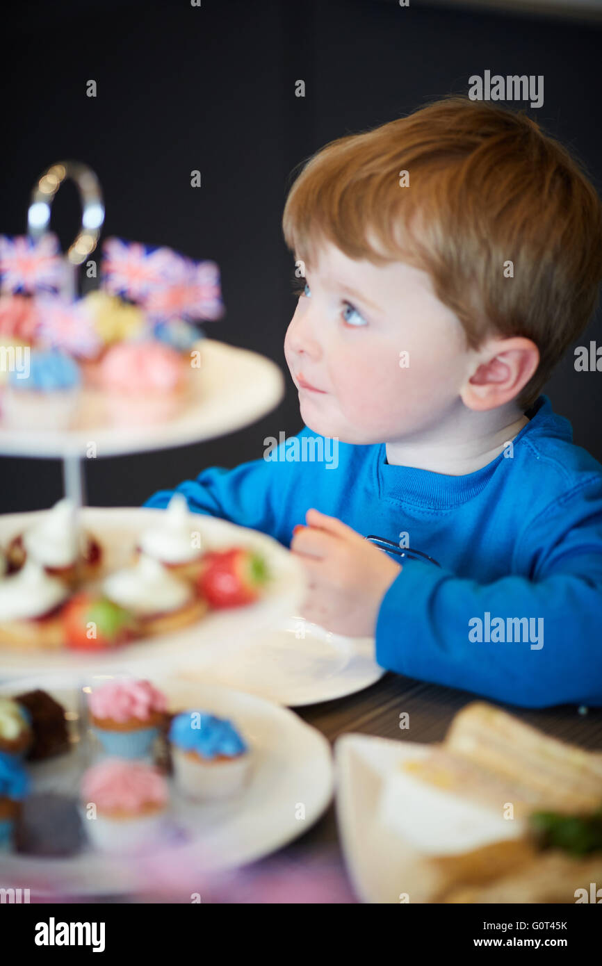 Kleiner Junge mit süßen Kuchen versucht Mann Männer männlich seine ihm He Jungs jungen Jungen Kids Kinder Jugendliche Kind Kleinkinder Adolescen Stockfoto