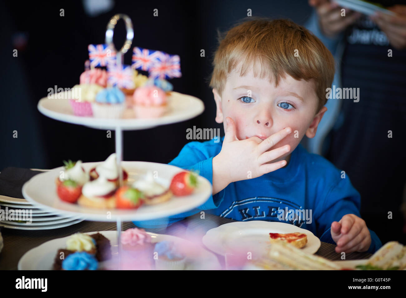 Kleiner Junge mit süßen Kuchen versucht Mann Männer männlich seine ihm He Jungs jungen Jungen Kids Kinder Jugendliche Kind Kleinkinder Adolescen Stockfoto