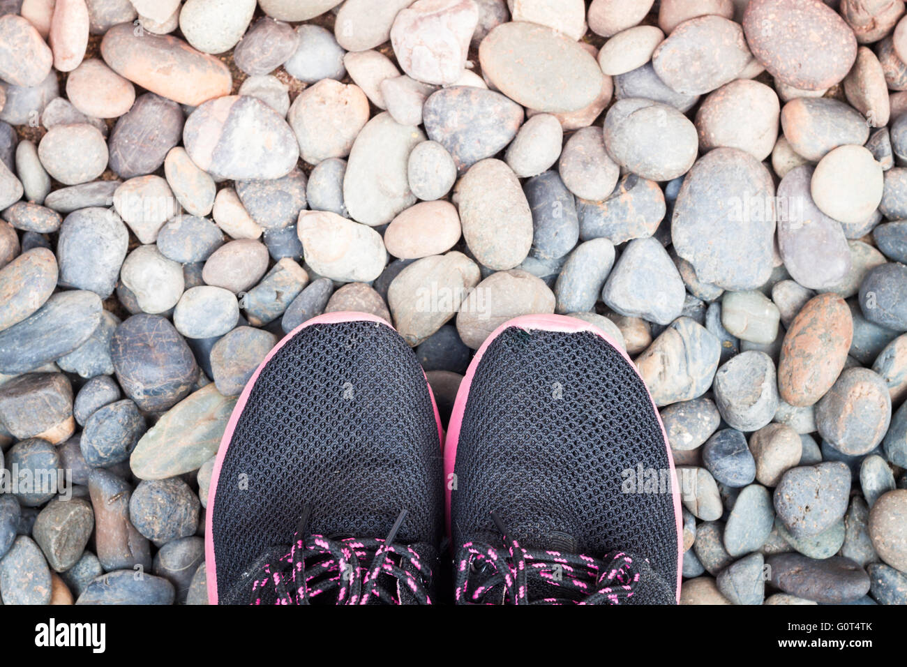 Laufschuhe im Hausgarten auf Kieselsteinen, Fotoarchiv Stockfoto