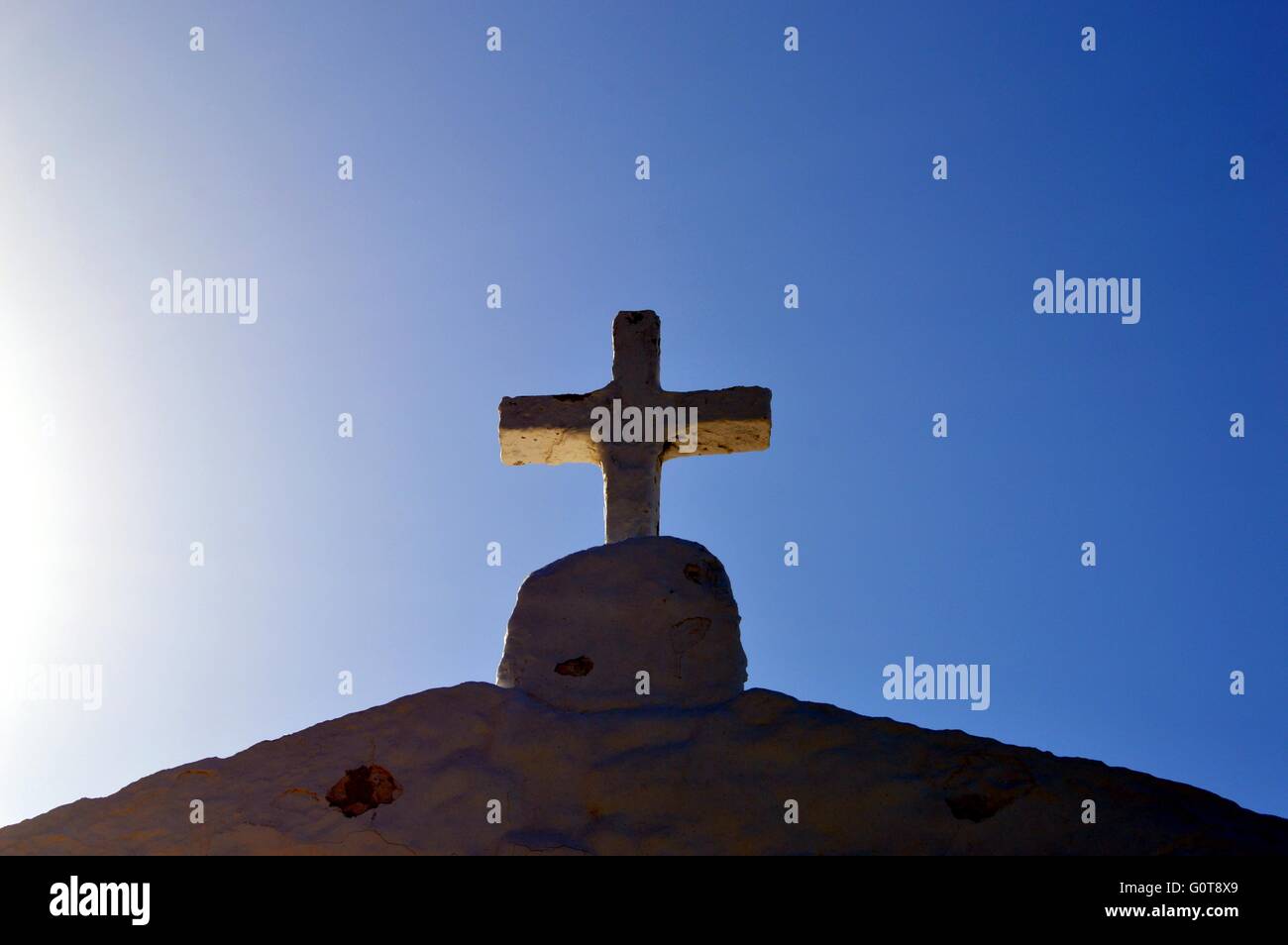 Konkrete Kreuz auf im Dach mit einem Sonnenuntergang und einem blauen Himmel. Stockfoto