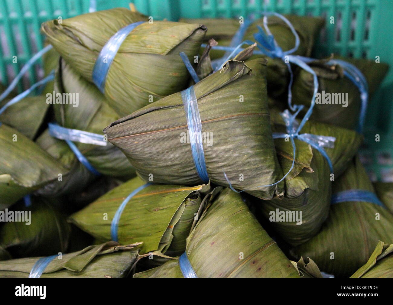 Chinesische klebrige Reisknödel, oder zong zi, in Bambusblätter gewickelt, die während der Duanwu- oder chinesischen Dumpling-Festfeier gegessen werden. Stockfoto