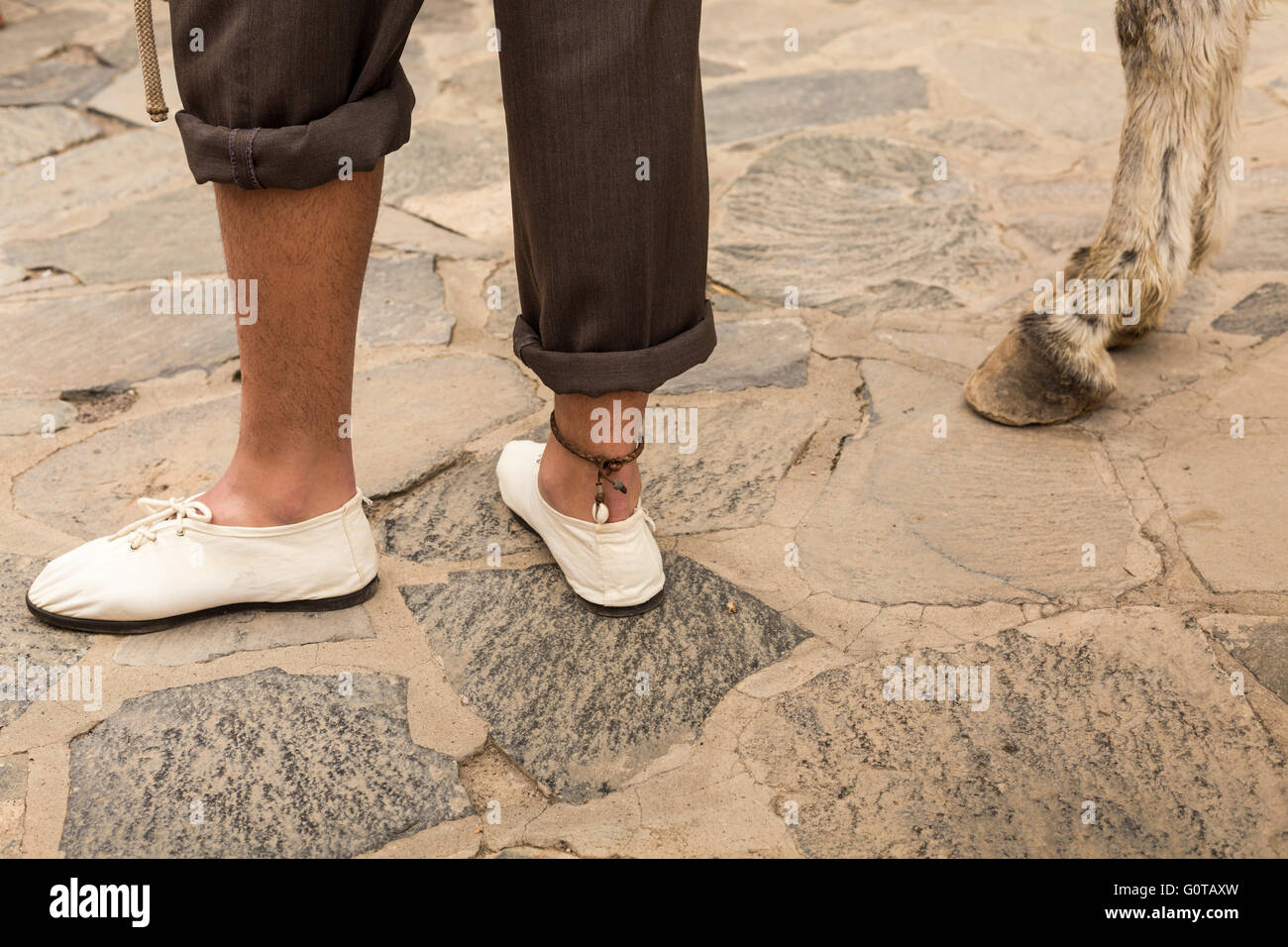 Mans, Beine und Füße mit Leder Fußkettchen neben Esel Hufe, Adeje, Teneriffa, Kanarische Inseln, Spanien. Stockfoto
