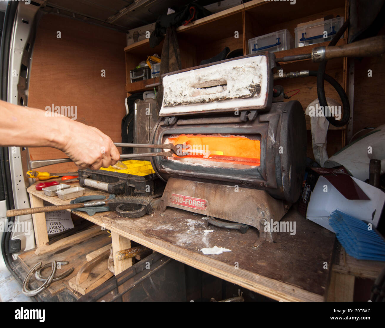 Hufschmied heiß beschlagen eines Pferdes in einem beständigen yard Stockfoto