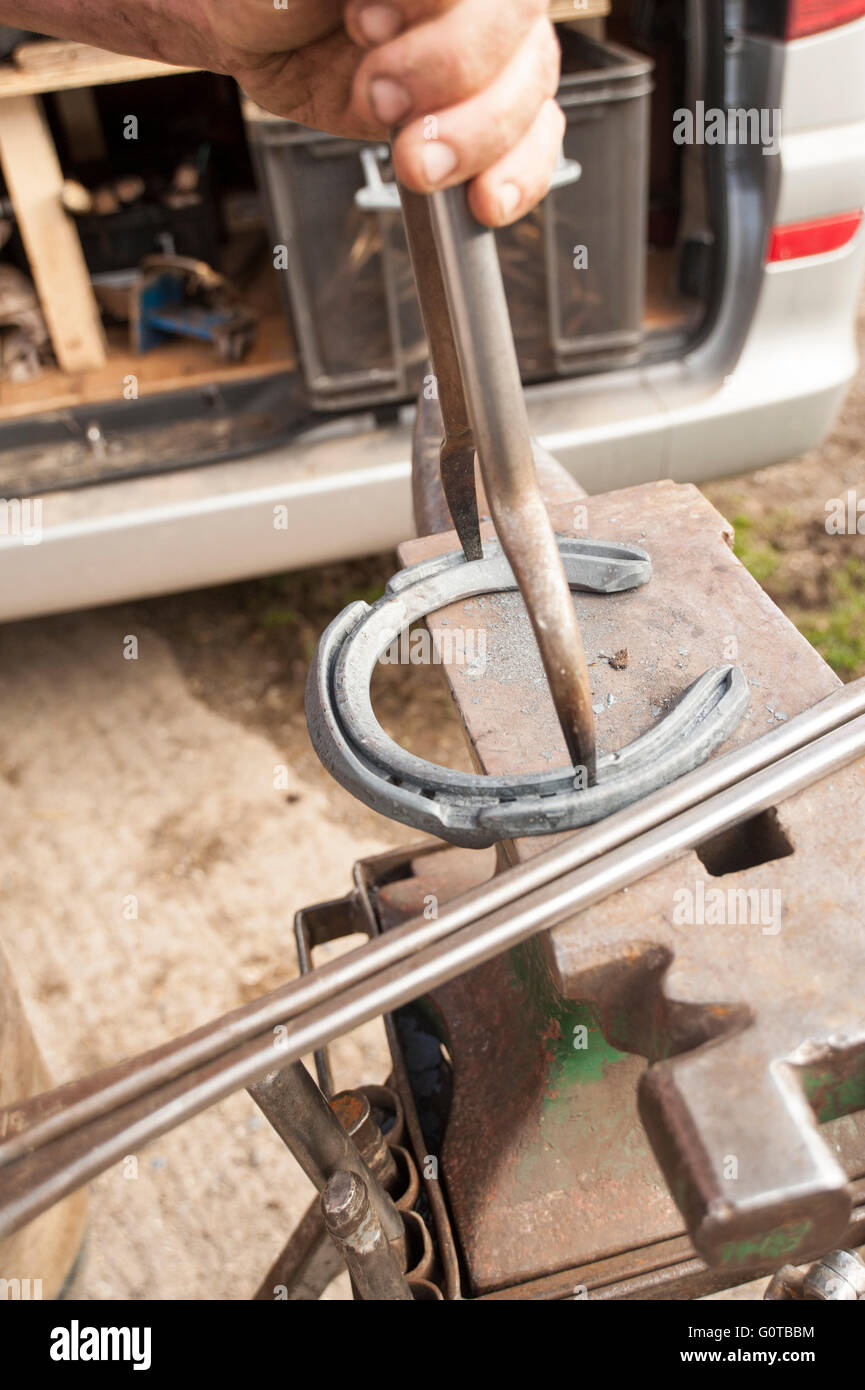 Hufschmied heiß beschlagen eines Pferdes in einem beständigen yard Stockfoto