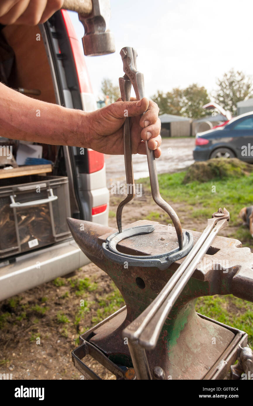 Hufschmied heiß beschlagen eines Pferdes in einem beständigen yard Stockfoto
