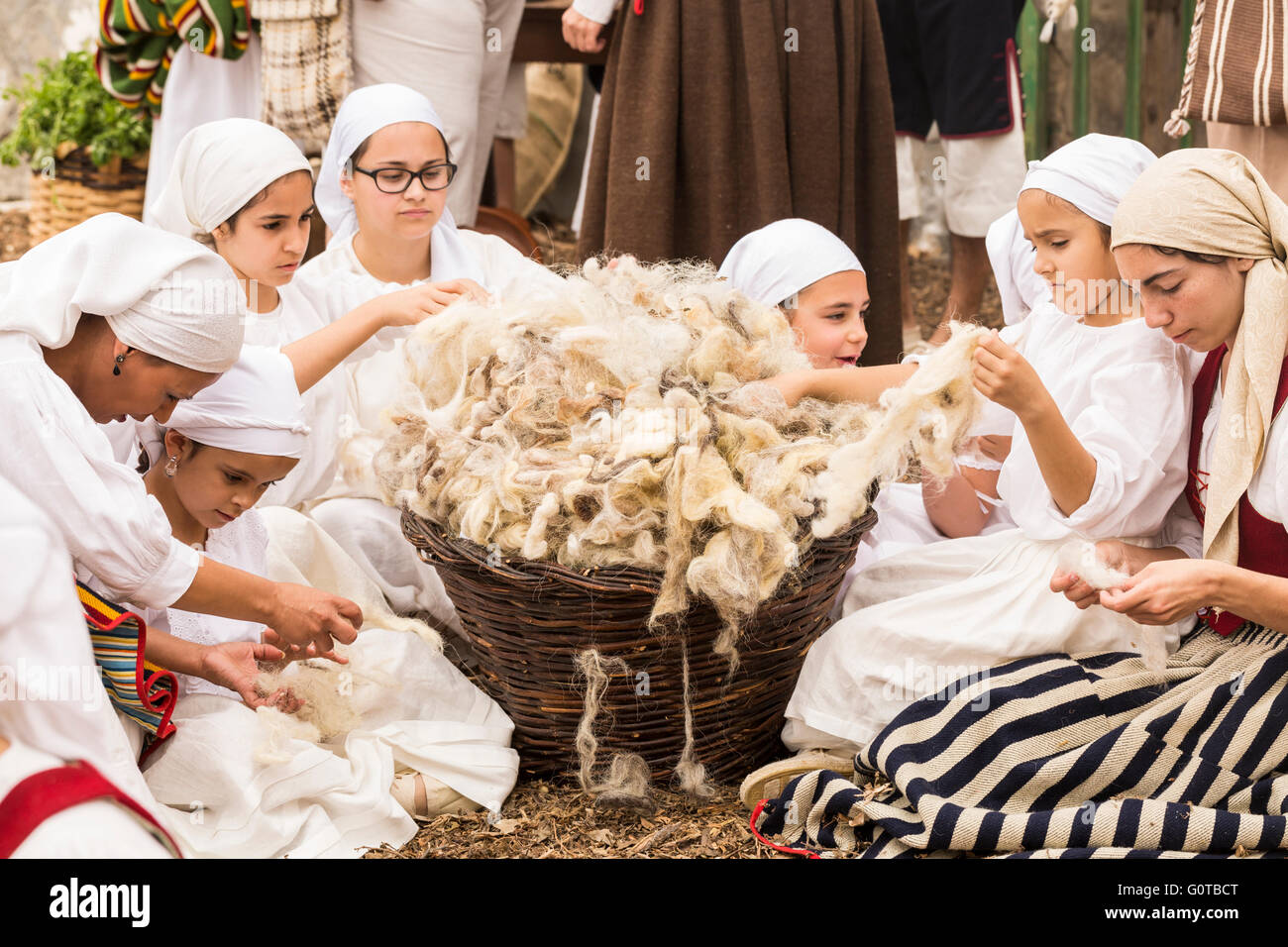 Mädchen in traditioneller Kleidung ziehen Garne aus Ziegen woolin eine Szene als Teil einer geführten theatralischen Route durch Wasser Adeje, Teneriffa, Kanaren, Isl Stockfoto