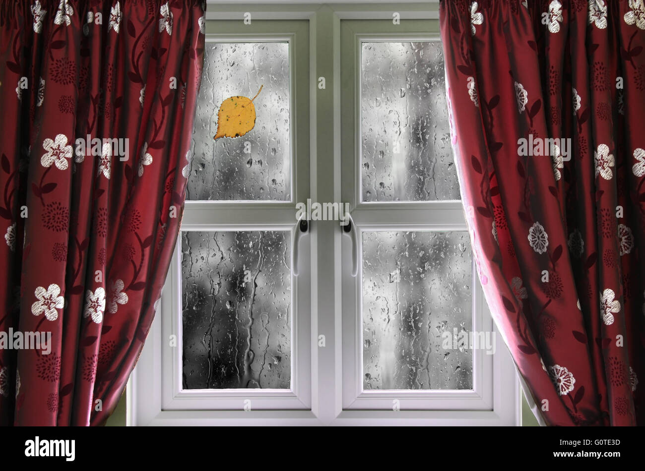 Regen Sie auf ein Fenster mit Vorhängen Stockfoto