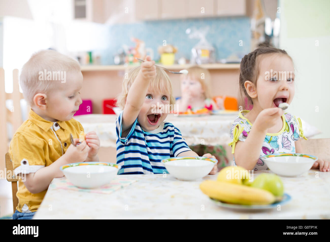 Lustiges kleines Kind spielen und Essen im kindergarten Stockfoto