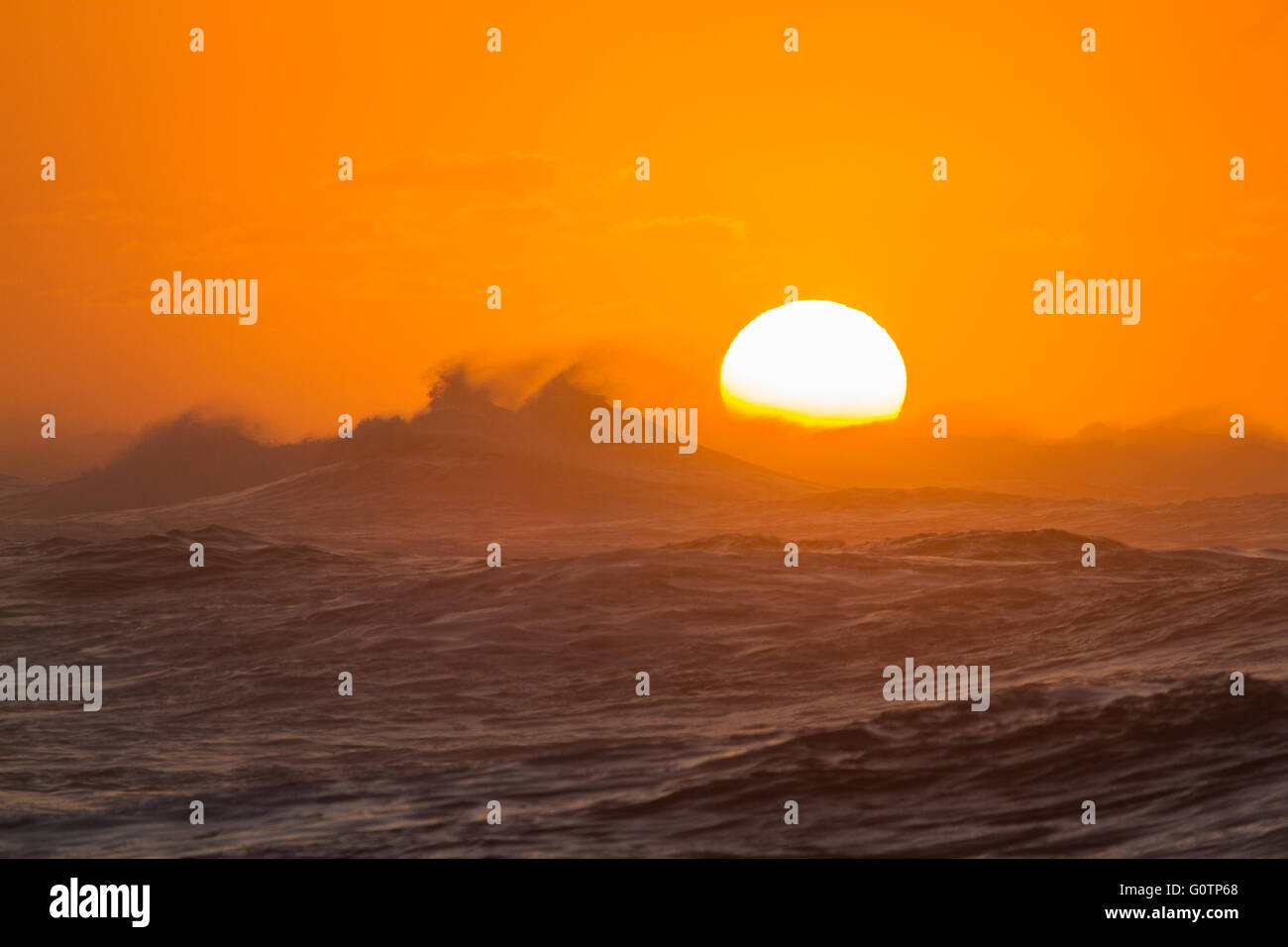 Sonnenuntergang hinter Roaring Hawaiian Surf Stockfoto