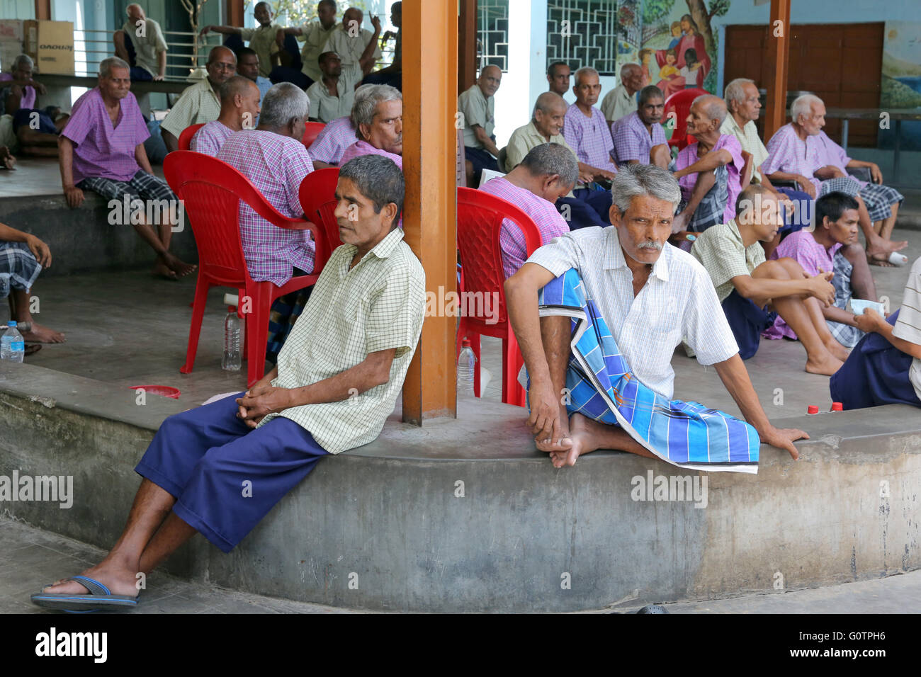 Alte Männer sitzen im Hof der "Prem Dan Heimstadion für Kranke und sterbende" Missionarinnen der Nächstenliebe (Mutter Teresa Sisters) in Kalkutta, Indien Stockfoto