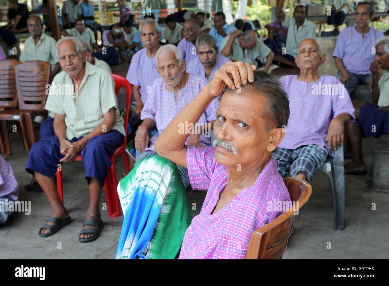 Alte Männer sitzen im Hof der "Prem Dan Heimstadion für Kranke und sterbende" Missionarinnen der Nächstenliebe (Mutter Teresa Sisters) in Kalkutta, Indien Stockfoto
