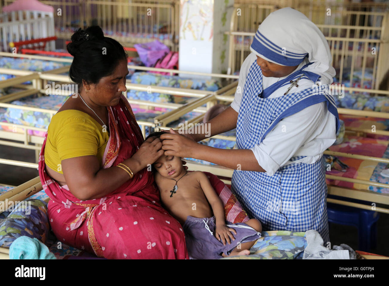 Teresa Sister Pflege einen kranken Jungen in der "Nirmala Shishu Bhawan Childrens Home" von den Missionarinnen der Nächstenliebe (Mutter Teresa Sisters) in Kalkutta, Indien Stockfoto