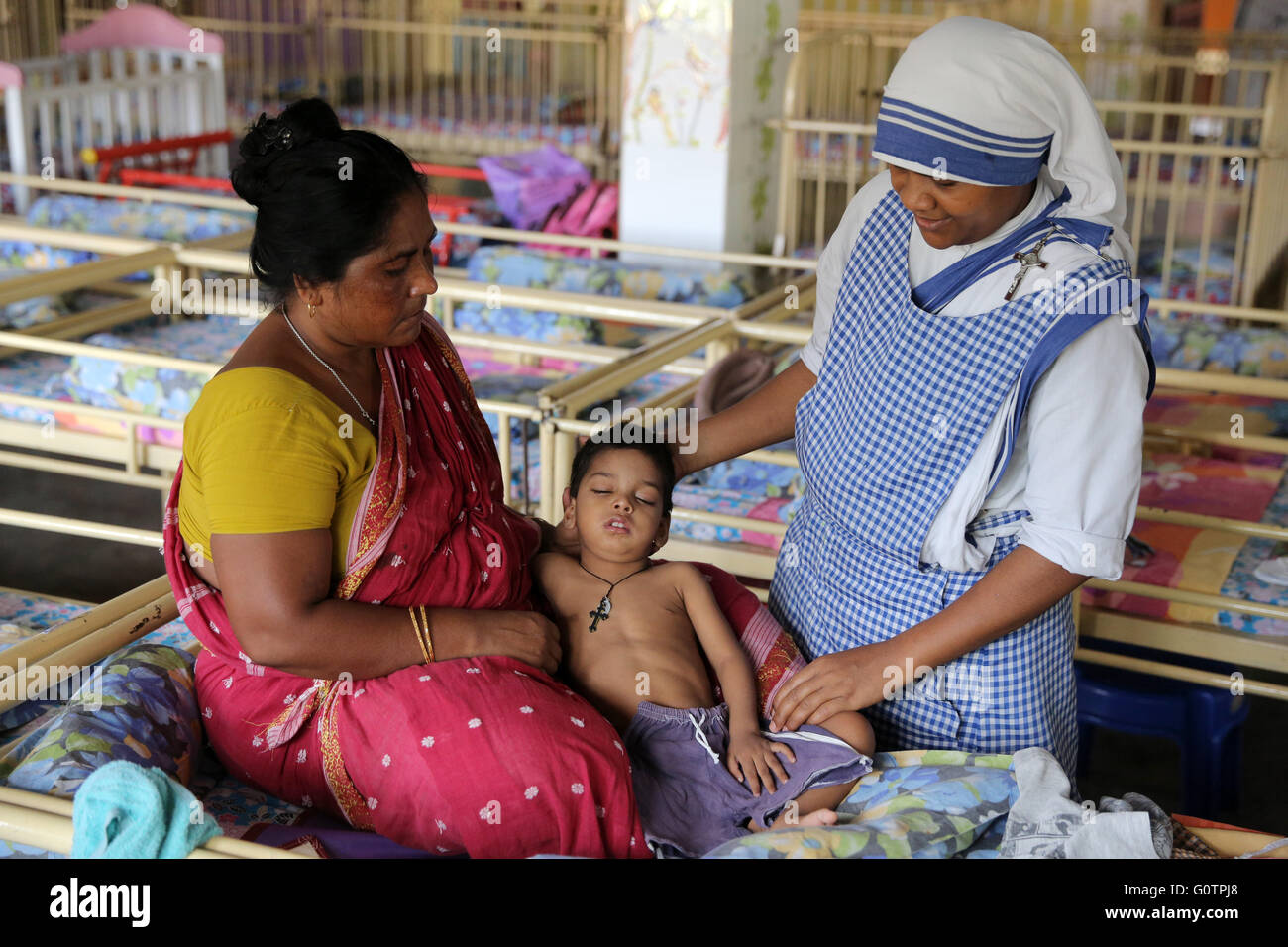 Teresa Sister Pflege einen kranken Jungen in der "Nirmala Shishu Bhawan Childrens Home" von den Missionarinnen der Nächstenliebe (Mutter Teresa Sisters) in Kalkutta, Indien Stockfoto