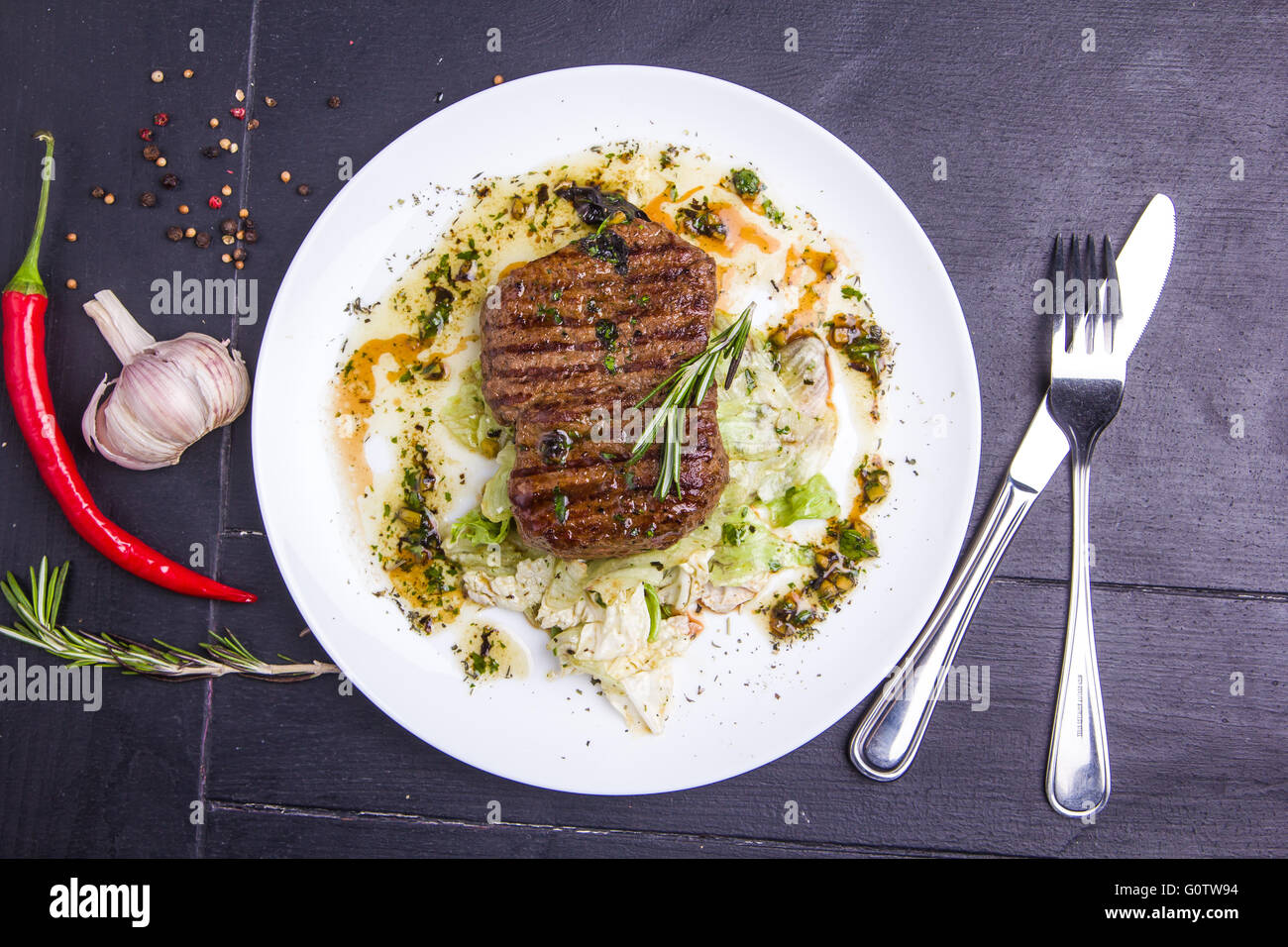 Konzept: gesunde Ernährung. Hausgemachte gegrilltes Kalbssteak und Gemüse auf einem Teller mit Zutaten und Besteck um Stockfoto