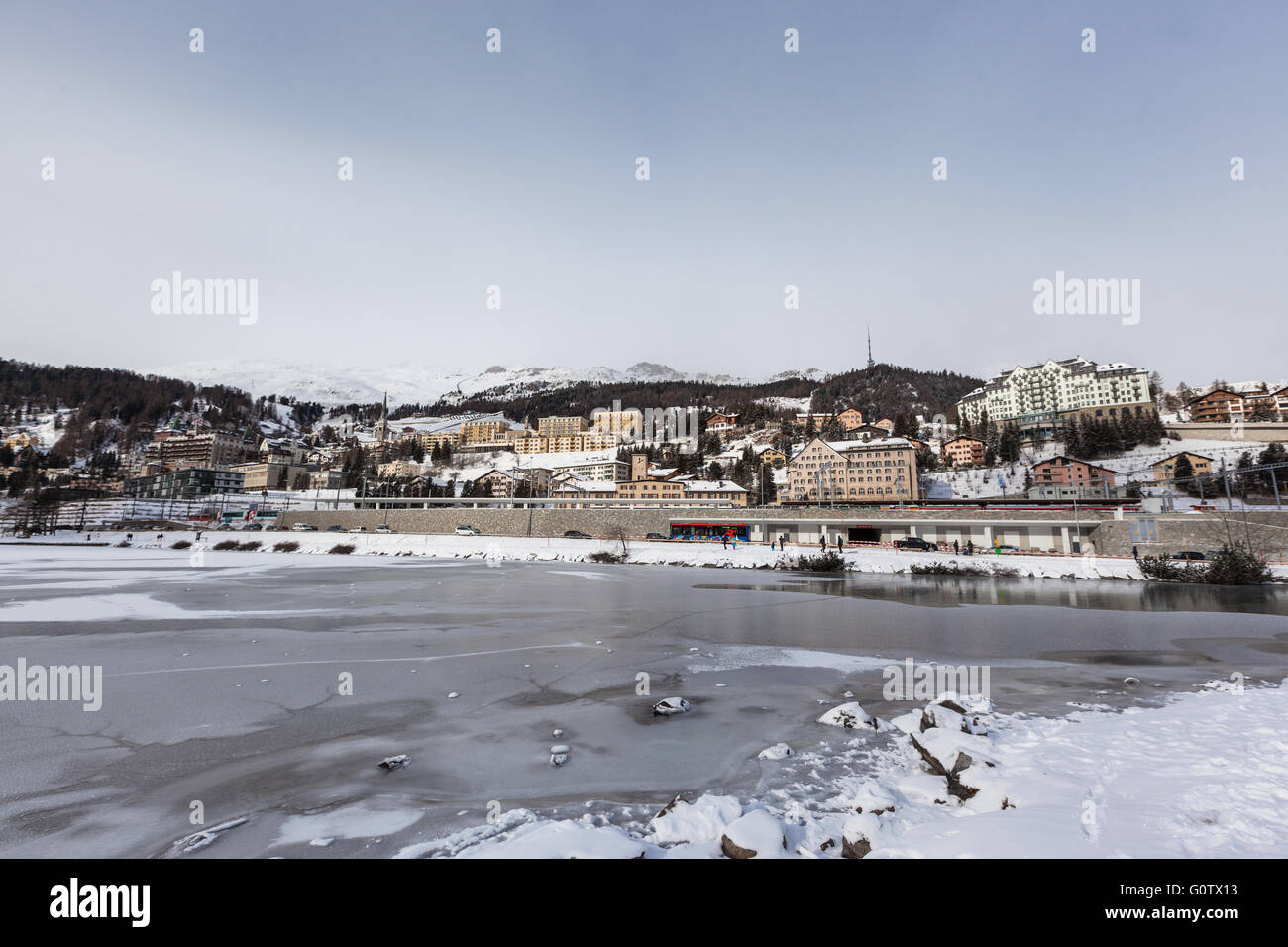 Blick auf den eisigen Sankt Moritzer See und die Stadt auf dem Berg im Winter, Graubünden, Schweiz Stockfoto