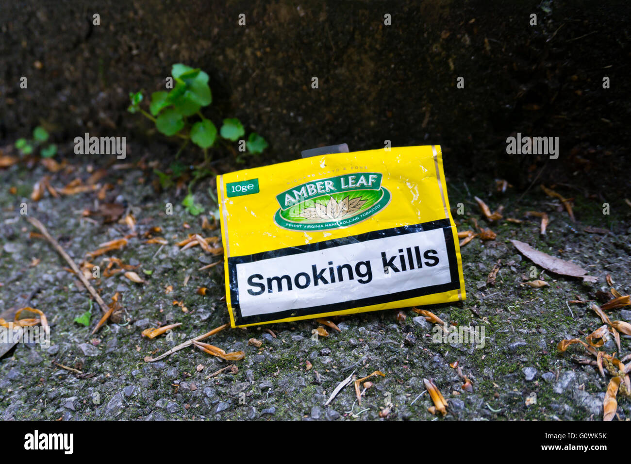 Eine ausrangierte Tabakbeutel mit dem gedruckten Slogan Warnung durch das Rauchen sterben. Stockfoto