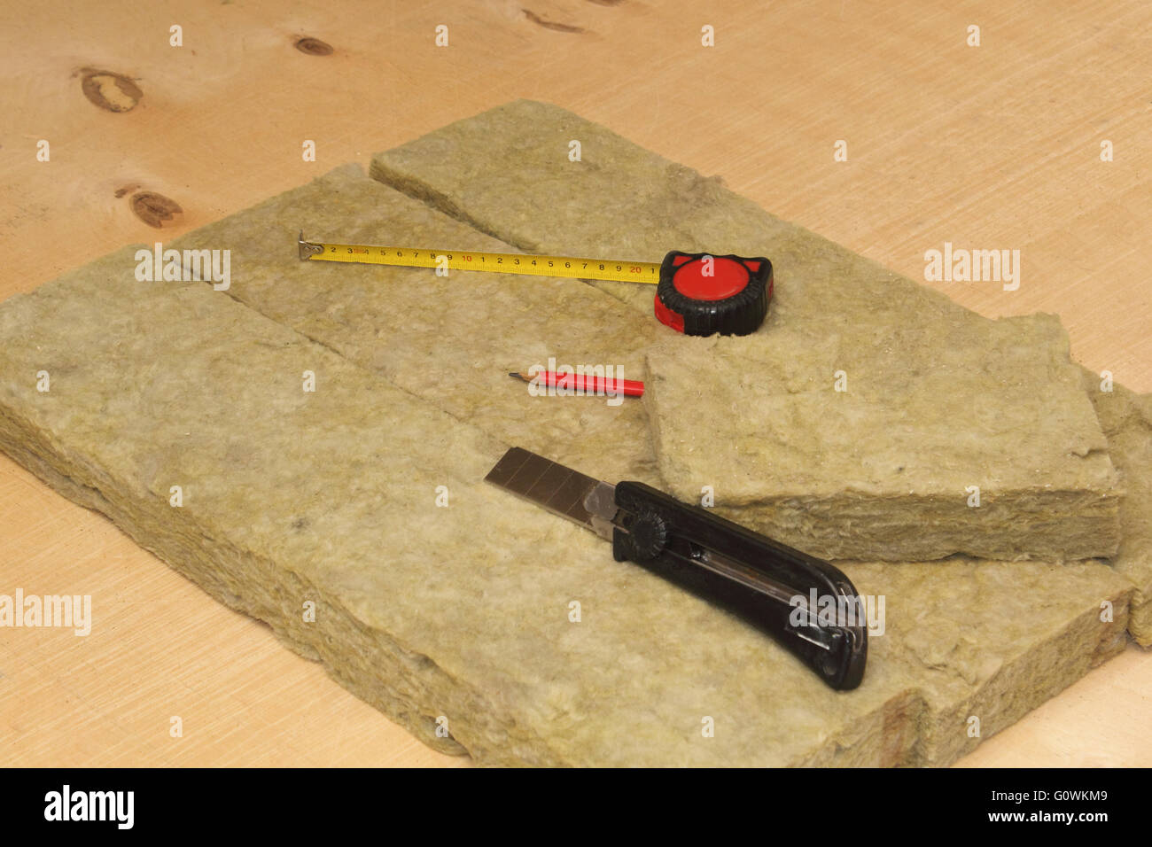 Geschnittenen Mineral Wolle, Messer, Bleistift und Maßband Foto Stockfoto