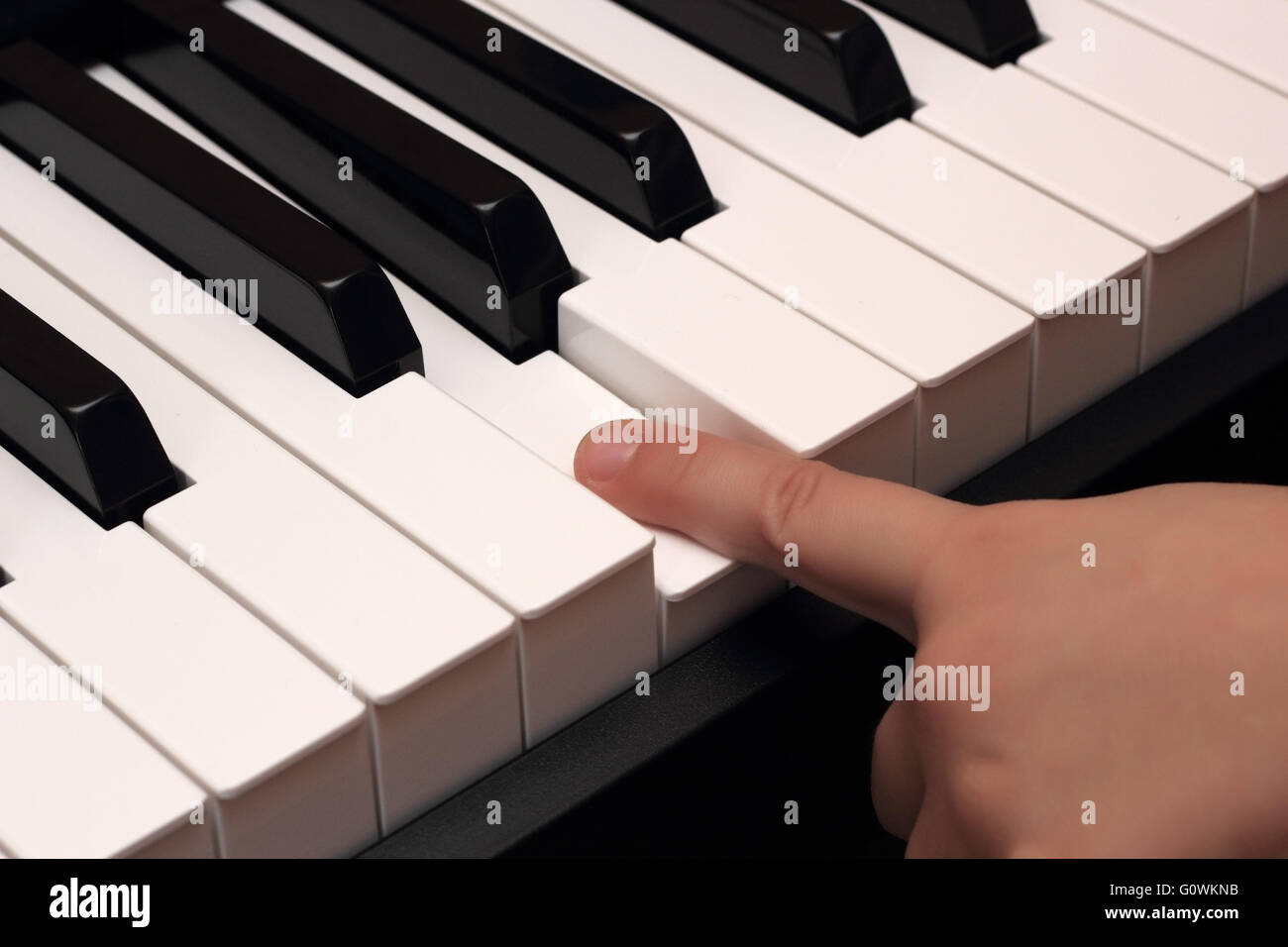 Kind-Finger drücken weiße Klavier Schlüsselfoto Stockfoto