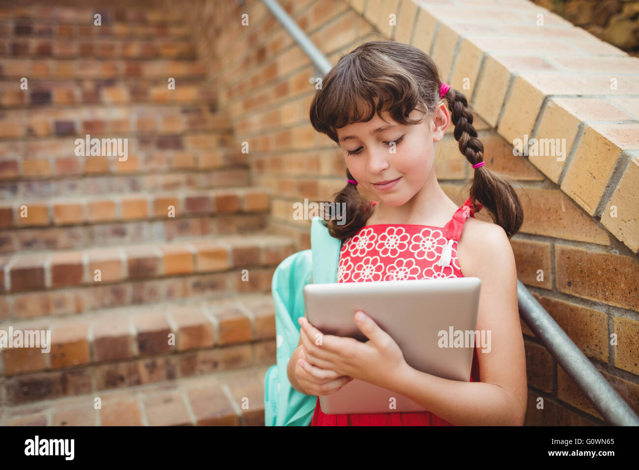 Brünette Schülerin sucht ihr digital-Tablette Stockfoto