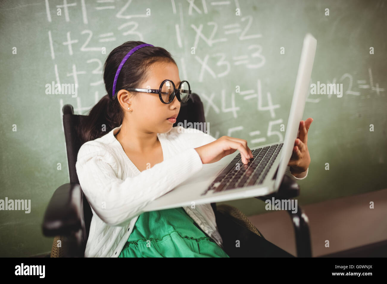 Kleines Mädchen mit großen Gläsern, die Eingabe auf ihrem laptop Stockfoto