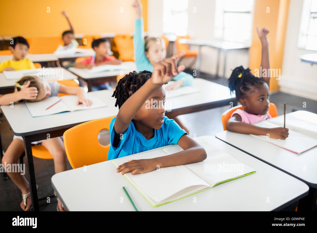 Schülerinnen und Schüler ihre Hände erhebend Stockfoto