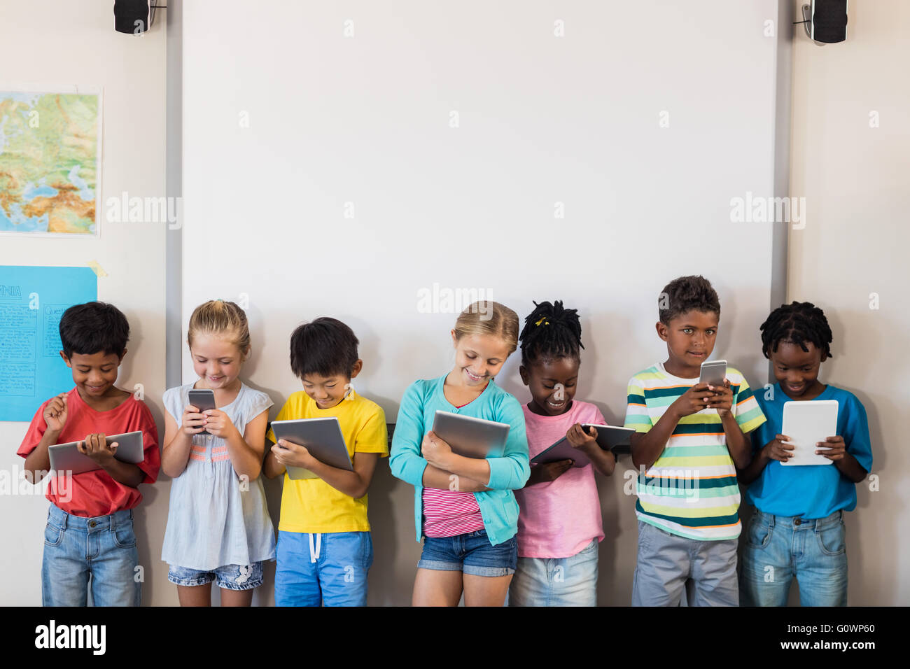 Schülerinnen und Schüler stehen mit Technologie Stockfoto