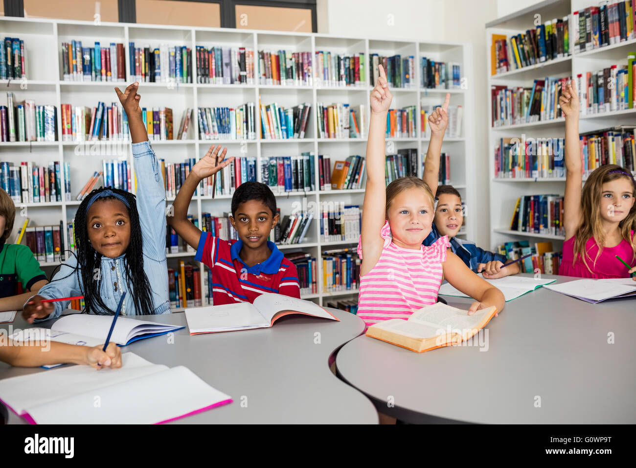 Schülerinnen und Schüler ihre Hände erhebend Stockfoto