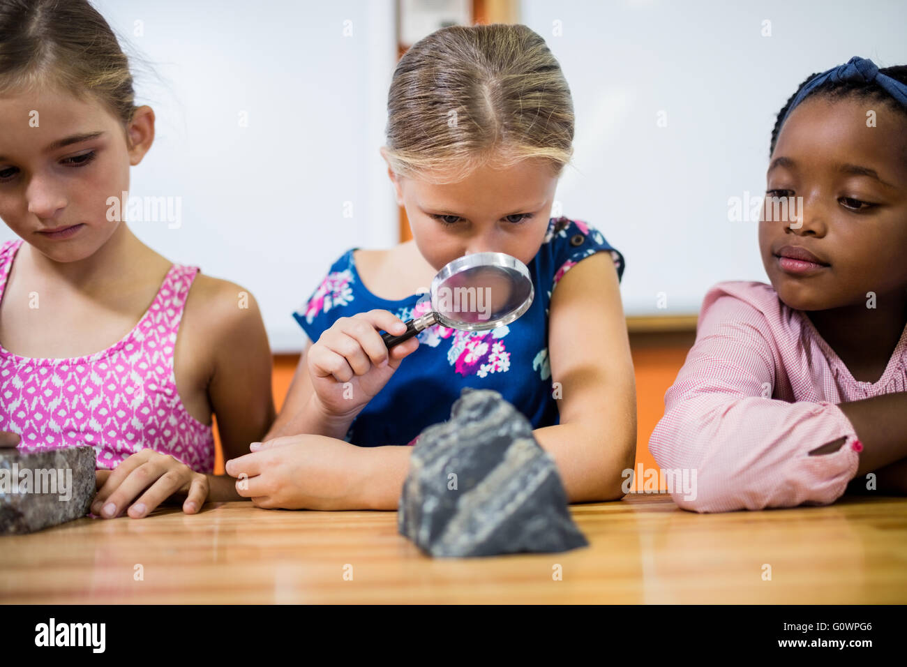 Kinder suchen Fossilien mit einer Lupe Stockfoto