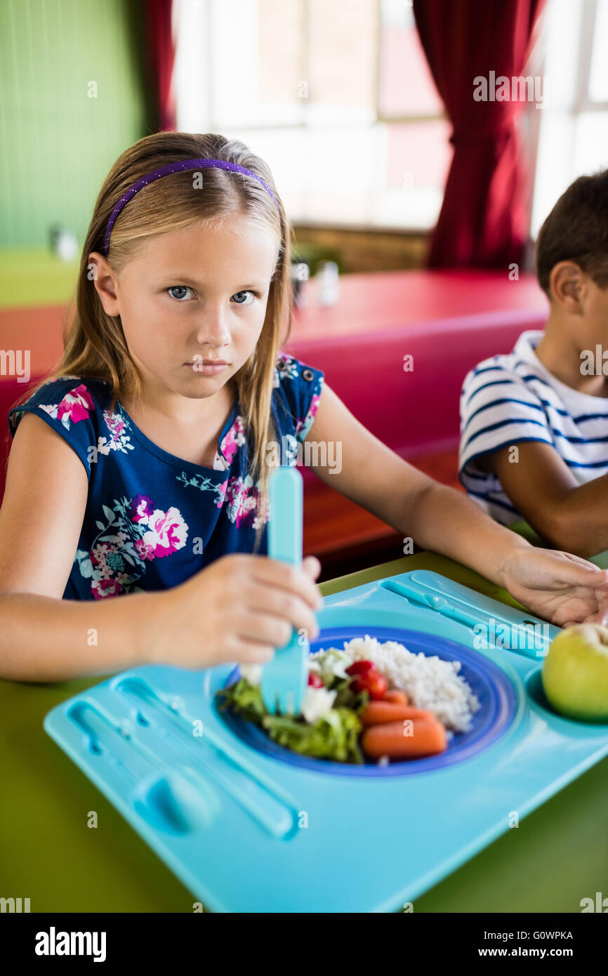 Kind in der Mensa essen Stockfoto