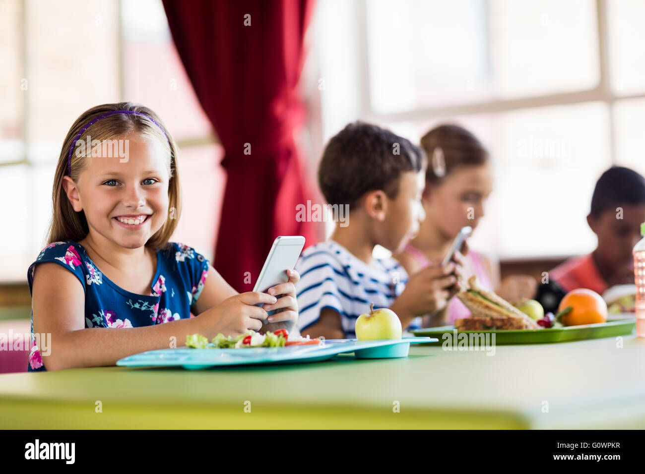 Kinder bei der Nutzung von Technologie in der Mittagspause Stockfoto