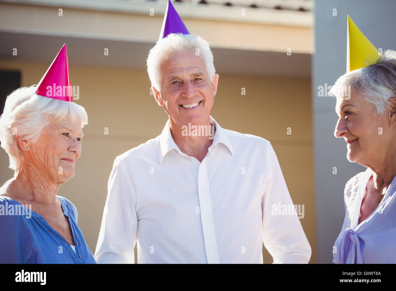 Porträt von Senioren lächelnd mit Partyhüte auf Kopf Stockfoto