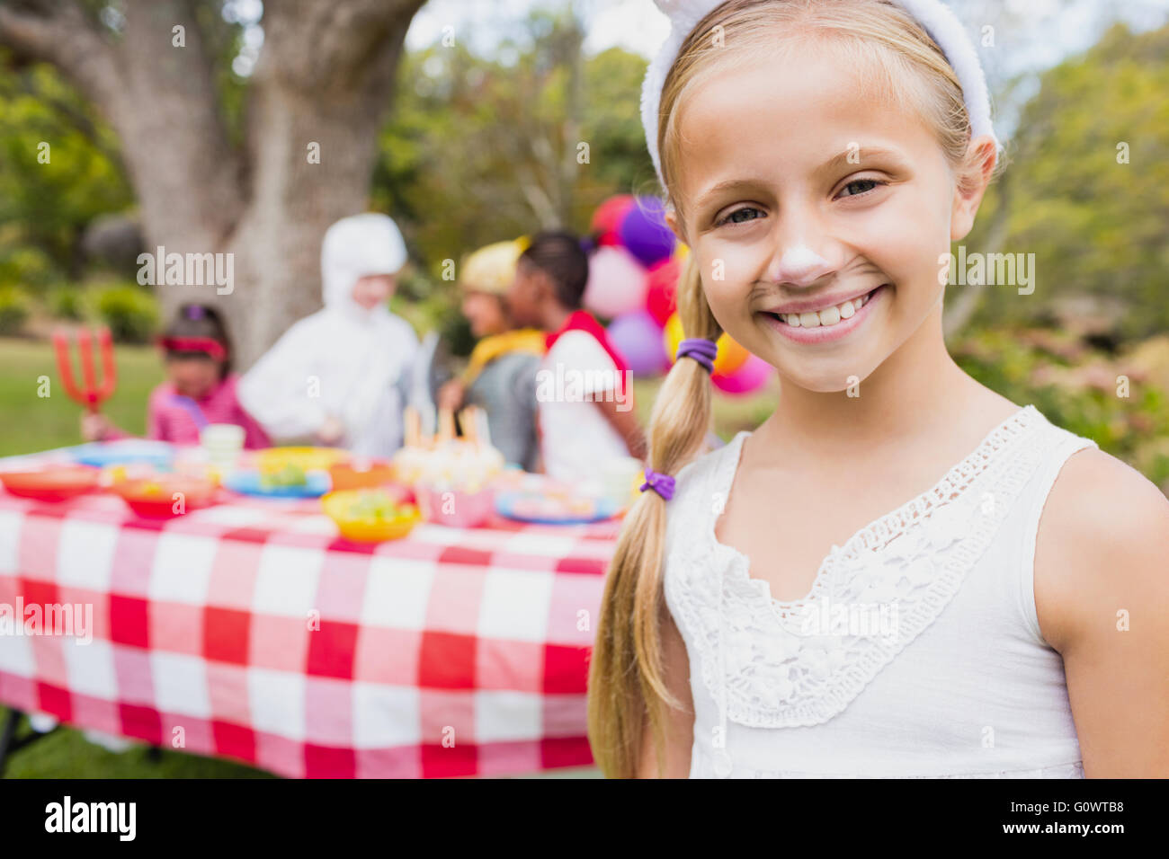 Lächelndes Mädchen tragen eine Kostüm während einer Geburtstagsfeier Stockfoto