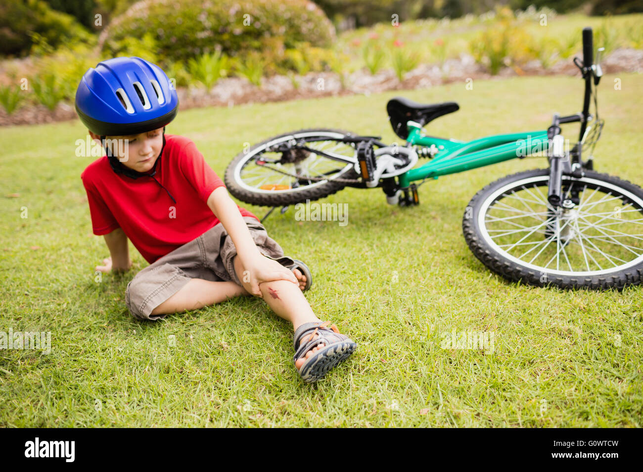 Trauriges Kind aus seinem Fahrrad fallen Stockfoto