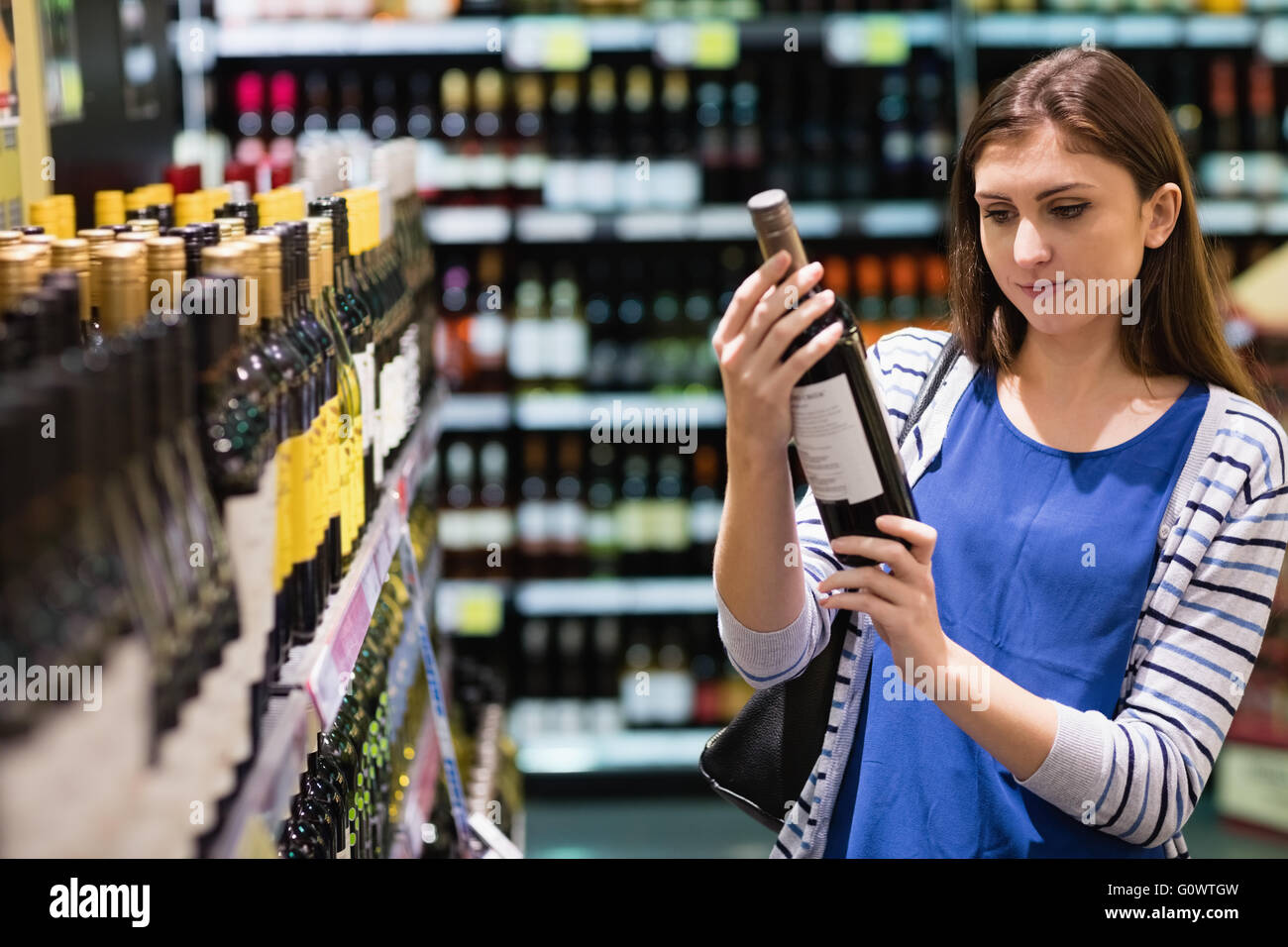 Frau auf der Suche nach Wein Flasche Stockfoto