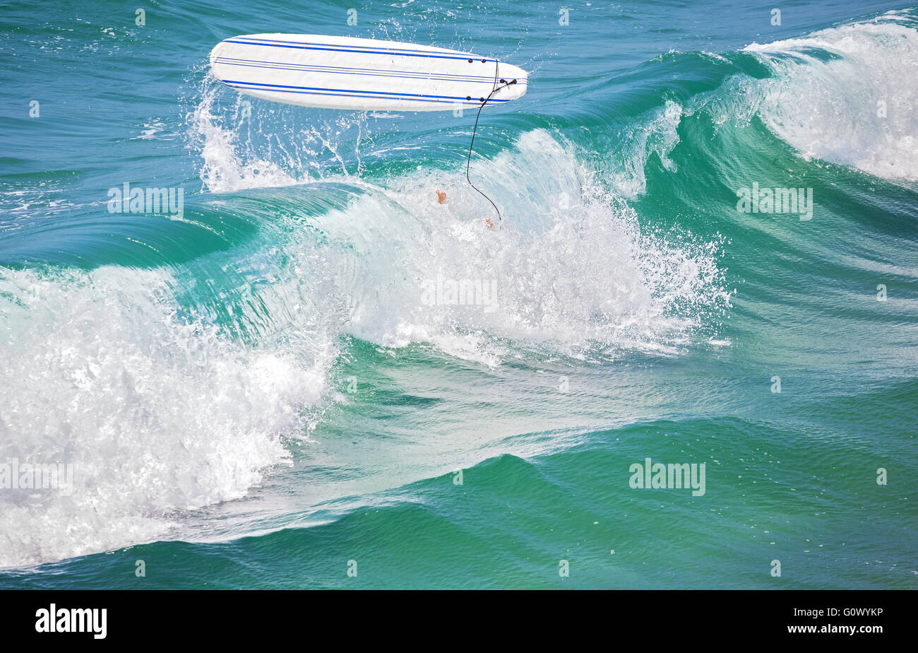 Surfer-Beine im Wasser und Surf Board in der Luft nach einem Sturz eine Welle. Stockfoto