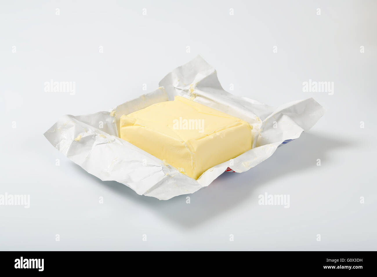 Block von frischer Butter auf weißem Hintergrund Stockfoto