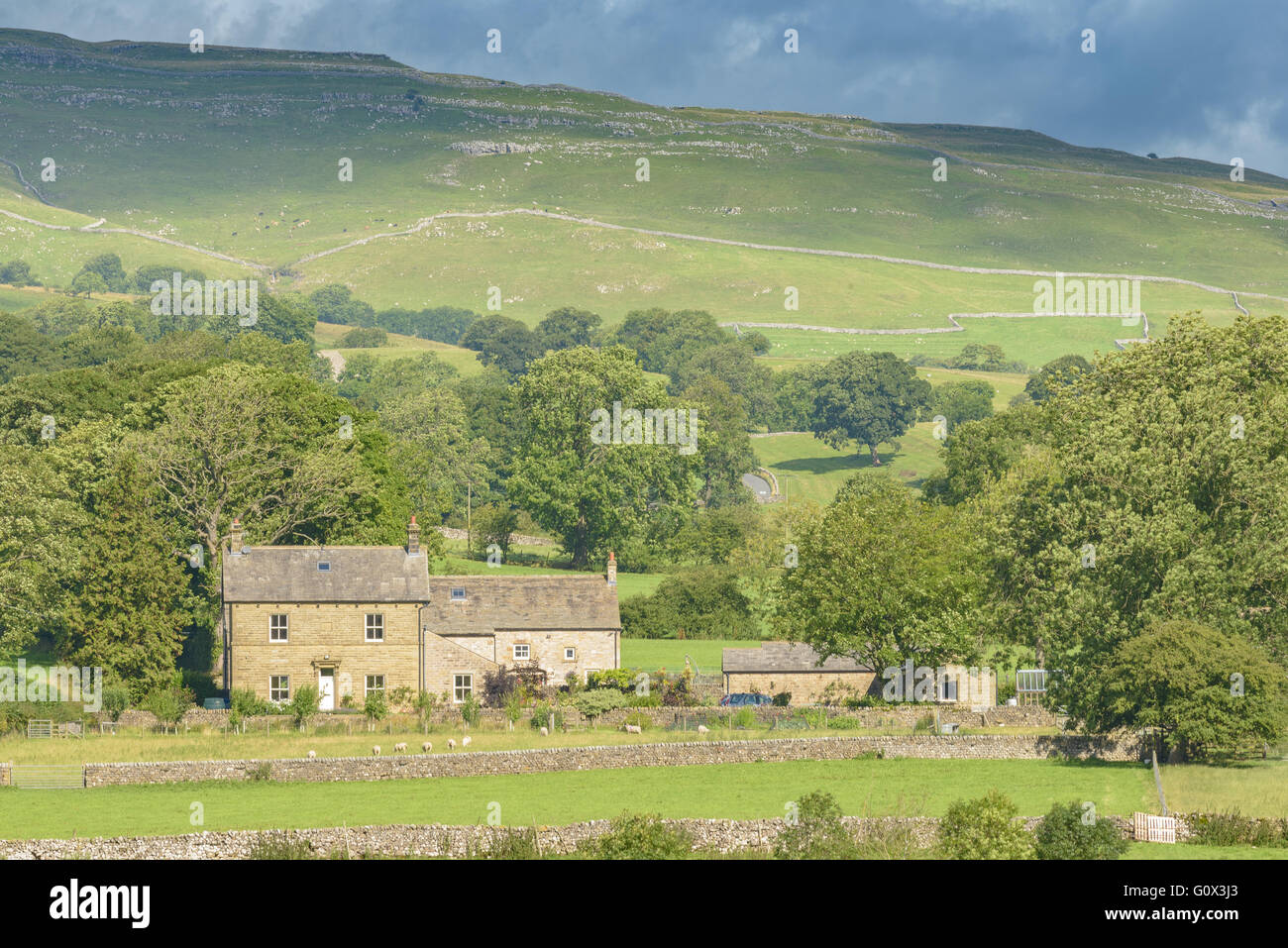 Ein Bauernhaus befindet sich am Fuße eines Hügels in den Yorkshire Dales in der Nähe von Skipton und Malham Cove Stockfoto